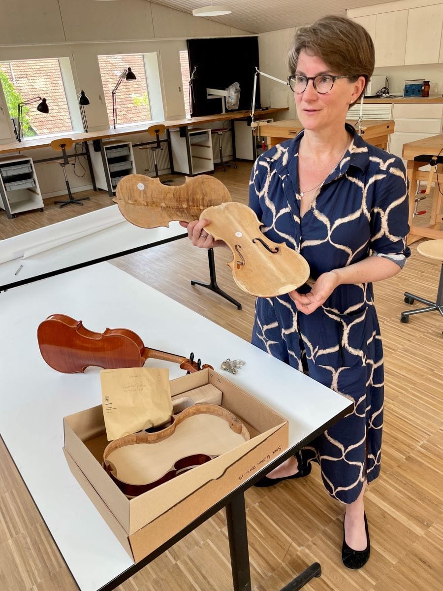 Geige1_BirgitSteinfels_web Bild Birgit Steinfels mit einer Holzgeige in der Hand. Die Holzgeige wurde noch nicht fertiggestellt.