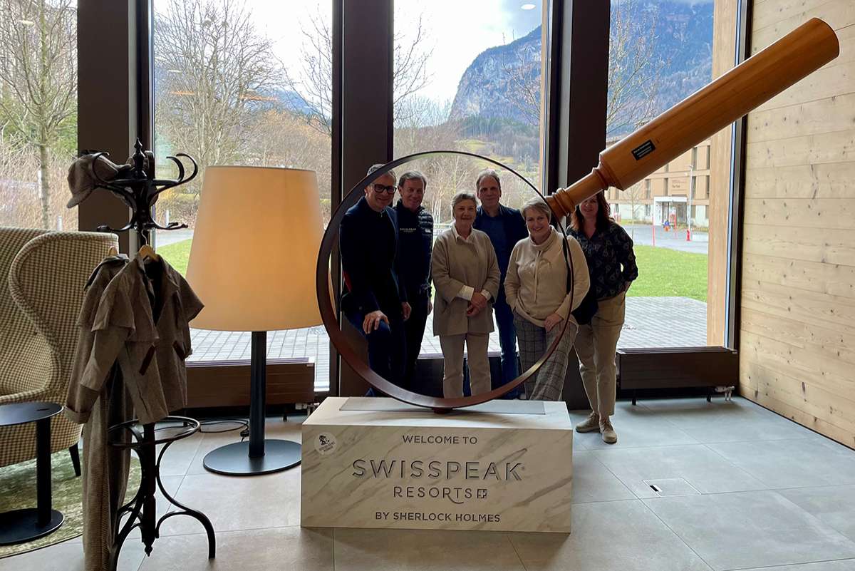2024-02-swisspeakresort-fb-web-1 Gruppenfoto vor der riesigen Lupe im Swisspeak Resort